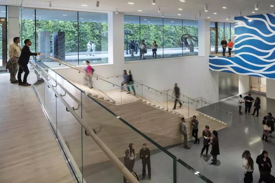 La gente sube y baja escaleras en un espacioso atrio del Museo de Arte Moderno de San Francisco (SFMOMA).